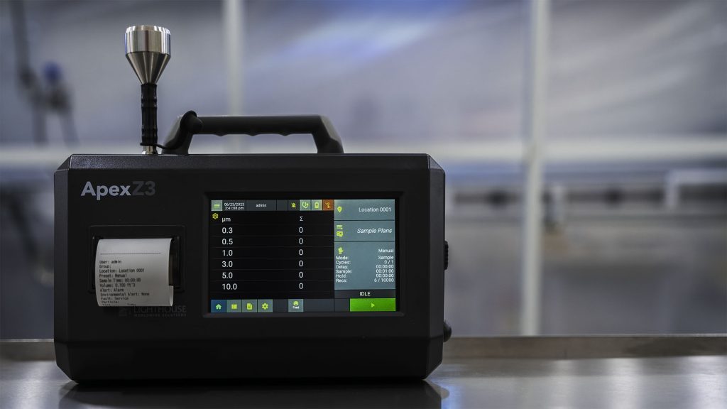 A photograph of an LWS ApexZ portable airborne particle counter in a laboratory setting.
