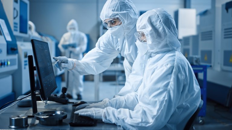 Cleanroom workers looking at computer data