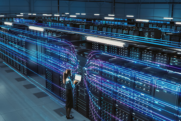 female technician standing in from of computer servers in a data center
